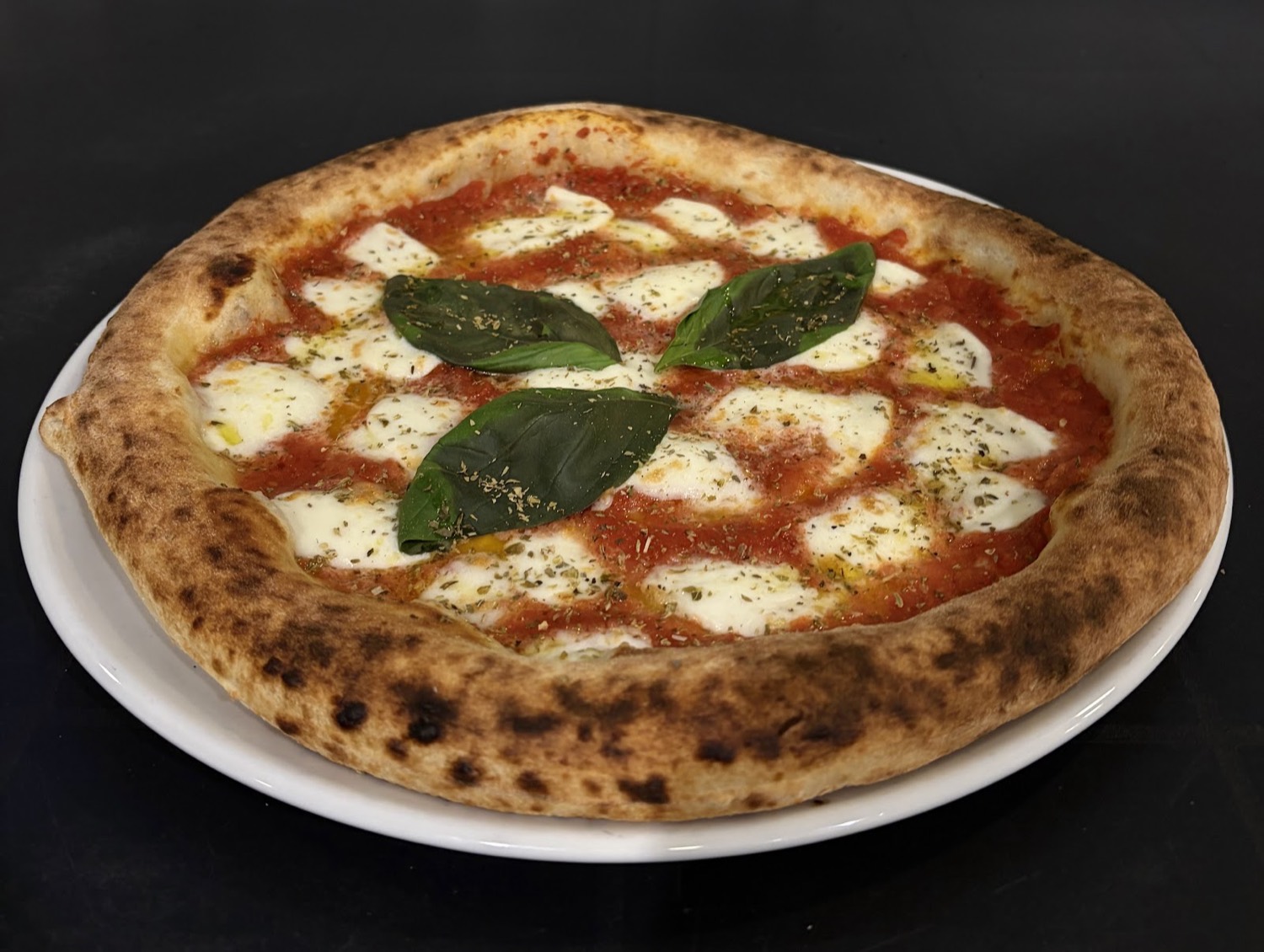 Pizza margherita con basilico appena sfornata
